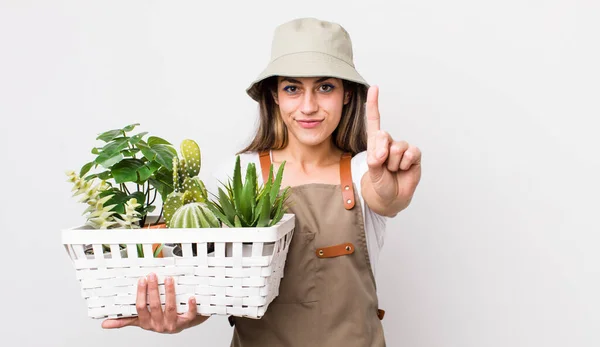 Pretty Hispanic Woman Smiling Looking Friendly Showing Number One Plants — Stock Photo, Image