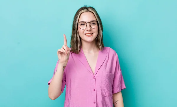 Pretty Caucasian Woman Smiling Looking Friendly Showing Number One First — Fotografia de Stock