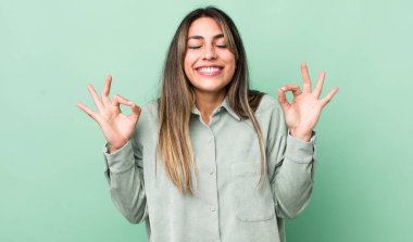 Güzel İspanyol bir kadın konsantre olmuş ve meditasyon yapıyor, tatmin olmuş ve rahatlamış hissediyor, düşünüyor ya da bir seçim yapıyor.