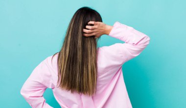 Düşünen, kuşkulanan, kafasını kaşıyan, kafası karışmış, kafası karışmış, arkadan ya da arkadan bakan İspanyol bir kadın.