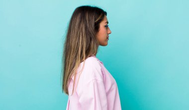 Profil görünümlü güzel İspanyol kadın ilerideki boşluğu kopyalamaya çalışıyor, düşünüyor, hayal ediyor ya da hayal kuruyor.