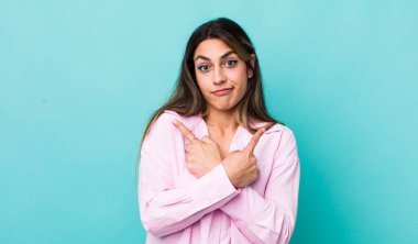 Şaşkın, kafası karışmış, kendine güveni olmayan ve zıt yönlere şüpheyle bakan İspanyol bir kadın.