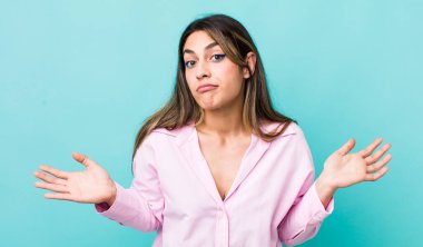 pretty hispanic woman feeling clueless and confused, having no idea, absolutely puzzled with a dumb or foolish look