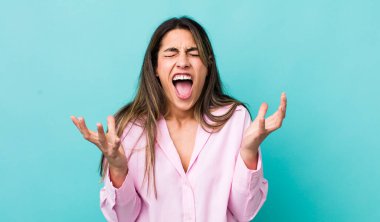 Güzel İspanyol bir kadın öfkeyle bağırıyor, stres altında ve elleri havada neden ben diye bağırıyor.