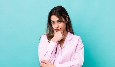 Güzel İspanyol kadın ciddi görünüyor, kafası karışık, kararsız ve düşünceli, seçenekler ve seçimler arasında şüpheci.