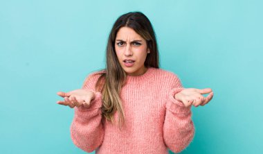 Hispanik bir kadın, bilgisiz ve kafası karışık, hangi seçeneği seçeceğinden emin değil, merak ediyor.