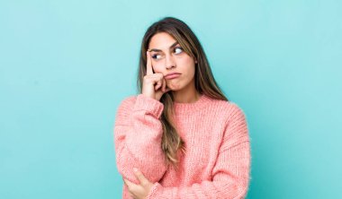 Güzel İspanyol bir kadın, yoğun bakışlı, şüpheli bir ifadeyle merak ediyor, yukarı ve yana bakıyor