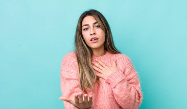 Güzel İspanyol bir kadın mutlu ve aşık, bir eli kalbinin yanında, diğer eli önde uzanmış, gülümsüyor.