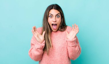 Güzel İspanyol bir kadın beklenmedik bir sürpriz yüzünden şoke olmuş, heyecanlı, gülen, şaşkın ve mutlu hissediyor.