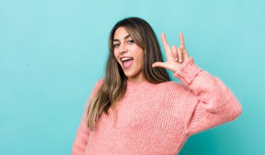 Oldukça İspanyol bir kadın mutlu, eğlenceli, kendinden emin, pozitif ve asi hissediyor, elle rock veya heavy metal işareti yapıyor.