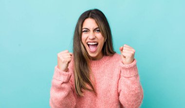 Güzel İspanyol bir kadın mutlu, pozitif ve başarılı hissediyor, zaferi, başarıları veya iyi şansı kutluyor.