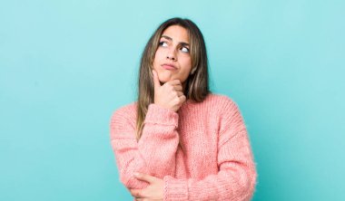 Güzel İspanyol bir kadın düşünceli, meraklı ya da hayal kuruyor, hayal kuruyor ve mekanı kopyalamak için yukarı bakıyor.