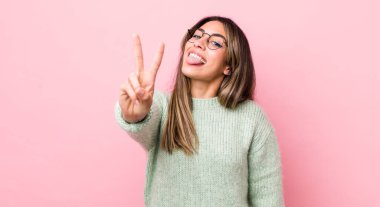 Güzel İspanyol kadın gülümsüyor ve arkadaş canlısı görünüyor. İki ya da iki numarayı gösteriyor. Elleri önde, geriye doğru sayıyor.