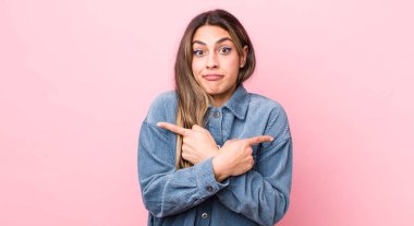 Şaşkın, kafası karışmış, kendine güveni olmayan ve zıt yönlere şüpheyle bakan İspanyol bir kadın.