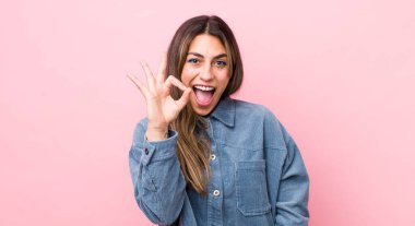 Güzel İspanyol bir kadın kendini başarılı ve tatmin olmuş hissediyor, ağzı açık gülümsüyor, elle imza atıyor.