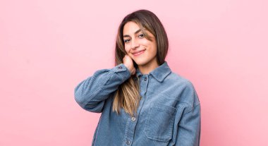 Güzel İspanyol kadın neşeli ve kendinden emin bir şekilde gülüyor. Sıradan, mutlu, dostane bir gülümsemeyle.