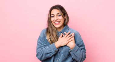 Güzel İspanyol bir kadın romantik, mutlu ve aşık, neşeyle gülümsüyor ve kalbe yakın el ele tutuşuyor.