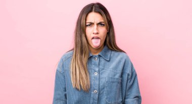 Güzel İspanyol bir kadın tiksinmiş ve rahatsız olmuş hissediyor, dilini dışarı çıkarıyor, iğrenç ve tiksindirici şeylerden hoşlanmıyor.