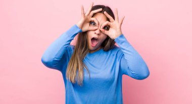 Güzel İspanyol kadın şaşkın, şaşkın ve şaşırmış hissediyor, elinde şaşkın, inançsız bir bakışla gözlük tutuyor.