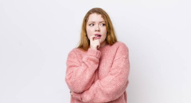 Şaşkın, gergin, endişeli ya da korkmuş bakışları olan güzel kızıl saçlı kadın, fotokopi uzayına bakıyor.