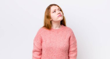 Güzel kızıl saçlı kadın endişeli, kafası karışık, budala bir ifadeyle, kopya alanı arıyor, şüpheci