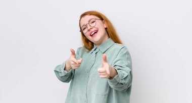 Güzel kızıl saçlı kadın kendini mutlu, havalı, tatmin olmuş, rahat ve başarılı hissediyor, kameraya bakıyor, seni seçiyor.