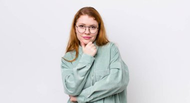 Güzel kızıl saçlı kadın ciddi görünüyor, kafası karışık, kararsız ve düşünceli, seçenekler ve seçimler arasında şüpheci.
