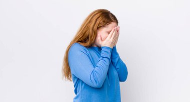 Güzel kızıl saçlı kadın, üzgün, hayal kırıklığına uğramış bakışlarıyla gözleri kapatıyor, ağlıyor, yan gözle bakıyor.