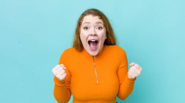 Güzel kızıl saçlı kadın şaşkın, heyecanlı ve mutlu hissediyor, gülüyor ve başarıyı kutluyor,!