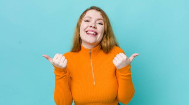 Güzel kızıl saçlı kadın neşeyle gülümsüyor ve mutlu görünüyor, kaygısız ve pozitif hissediyor.