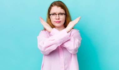 Güzel kızıl saçlı kadın senin tavırlarından rahatsız ve bıkkın görünüyor, yeter artık! Eller önde çapraz, durmanı söylüyor.