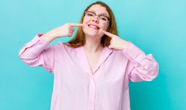 Güzel, kızıl saçlı, kendine güvenen, gülümseyen, pozitif, rahat, tatmin olmuş bir kadın.