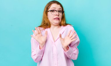 Güzel kızıl saçlı kadın gergin, endişeli ve endişeli görünüyor. Benim hatam olmadığını söylüyor. Yoksa ben yapmadım. 