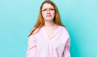 Güzel kızıl saçlı kadın üzgün ve mızmız, mutsuz bir bakışla, olumsuz ve hayal kırıklığına uğramış bir tavırla ağlıyor.