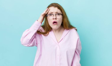 Güzel kızıl saçlı kadın şaşırmış, ağzı açık, şok olmuş, yeni bir düşünce, fikir ya da konsept keşfediyor.