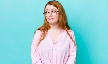 Güzel kızıl saçlı kadın merak ediyor, mutlu düşünceler ve fikirler düşünüyor, hayal kuruyor, kenarda yer arıyor.