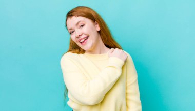 Güzel kızıl saçlı kadın mutlu, pozitif ve başarılı hissediyor, meydan okumayla karşılaştığında motive oluyor ya da iyi sonuçları kutluyor.