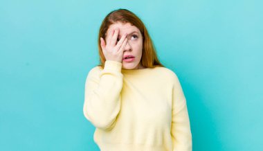 Güzel kızıl saçlı kadın, yorgun, sıkıcı ve sıkıcı bir işten sonra sıkılmış, hayal kırıklığına uğramış ve uykulu hissediyor.