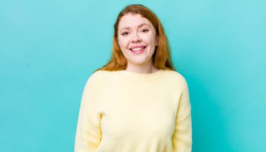 Güzel kızıl saçlı kadın mutlu ve hoş bir şekilde şaşırmış görünüyor. Büyülenmiş ve şok olmuş bir ifadeyle heyecanlanıyor.