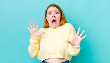 Güzel kızıl saçlı kadın sersemlemiş ve korkmuş hissediyor. Korkutucu bir şeyden korkuyor. Elleri açık ve uzak dur diyor.