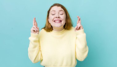 Güzel kızıl saçlı kadın gergin ve umutlu, şans diliyor ve dua ediyor.