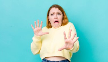 Güzel kızıl saçlı kadın korkmuş hissediyor, geri çekiliyor ve korku ve panik içinde çığlık atıyor, kabusa tepki veriyor.