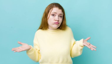 Güzel kızıl saçlı kadın şaşkın ve kafası karışık, doğru cevap ya da karardan emin değil, bir seçim yapmaya çalışıyor.