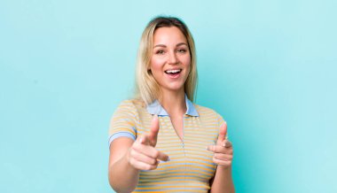 Güzel sarışın kadın kendini mutlu, havalı, tatmin olmuş, rahat ve başarılı hissediyor, kameraya bakıyor, seni seçiyor.