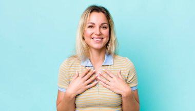 Güzel sarışın kadın mutlu, şaşırmış, gururlu ve heyecanlı görünüyor.