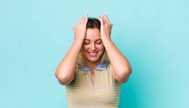 Güzel sarışın kadın stresli ve endişeli, depresif ve hayal kırıklığına uğramış hissediyor, iki elini de başa kaldırıyor.