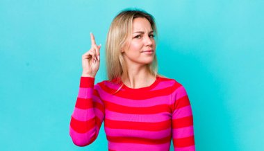 Güzel sarışın kadın, harika bir fikri fark ettikten sonra parmağını havaya kaldırıp 