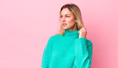 Güzel sarışın bir kadın stresli, endişeli, yorgun ve hayal kırıklığına uğramış, gömleğini çekiştiren, sorunlu görünüyor.