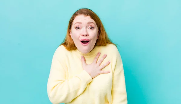 Bonita Mujer Pelirroja Sintiéndose Conmocionada Sorprendida Sonriendo Tomando Mano Corazón — Foto de Stock