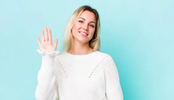 Pretty Blonde Woman Smiling Happily Cheerfully Waving Hand Welcoming Greeting — Stockfoto